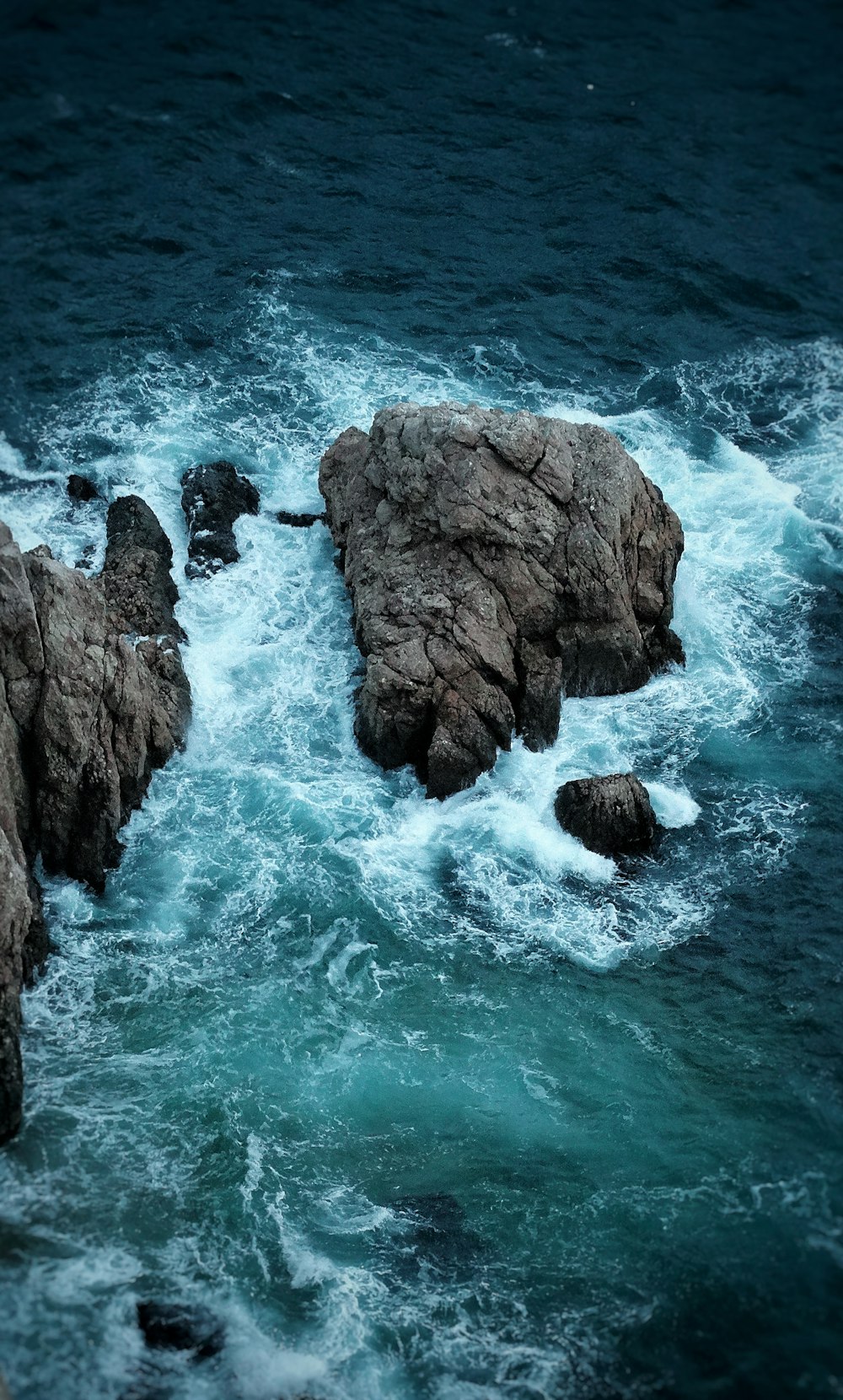 a rocky shoreline with waves crashing against it