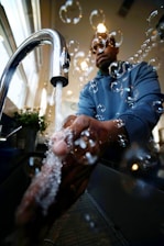 A friendly plumber from Flowfix Plumbers discussing project details with a homeowner in a modern kitchen.