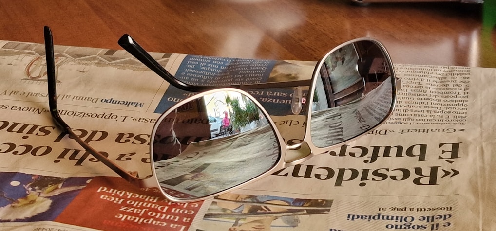 Close-up of sleek black sports smart sunglasses reflecting a sunny outdoor trail.