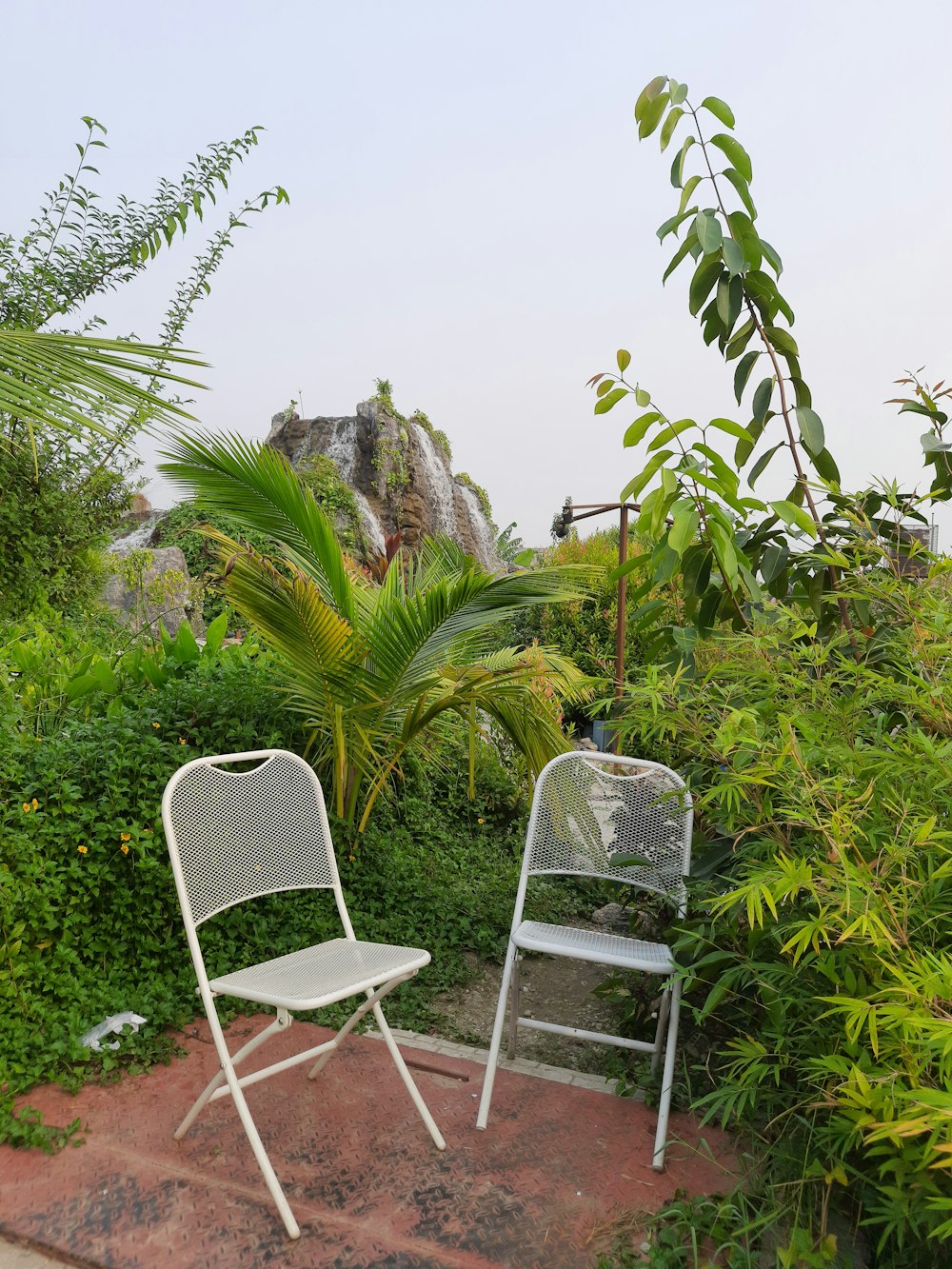 two white chairs on a brick patio