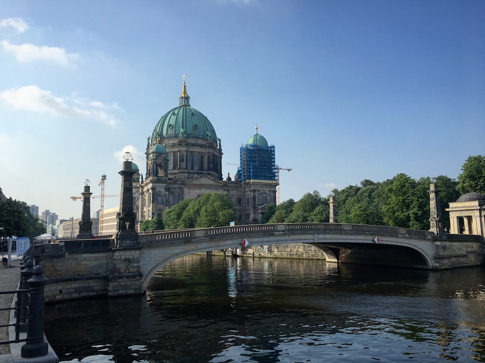 a bridge over a river with a building in the background