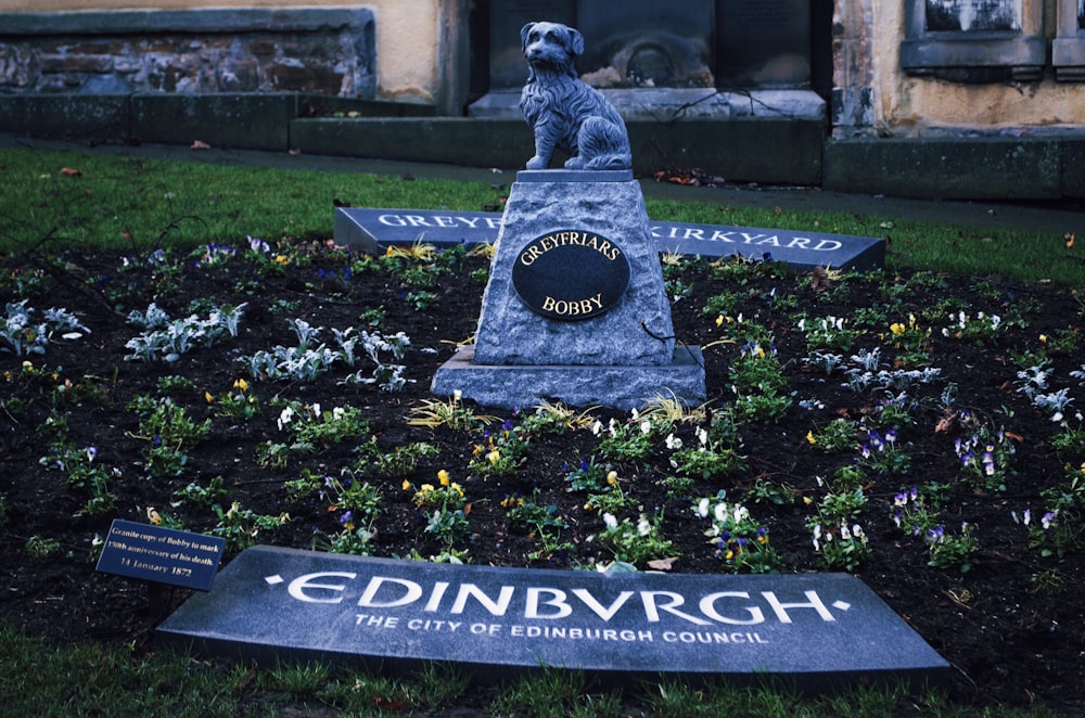 a statue of a dog on a grave stone