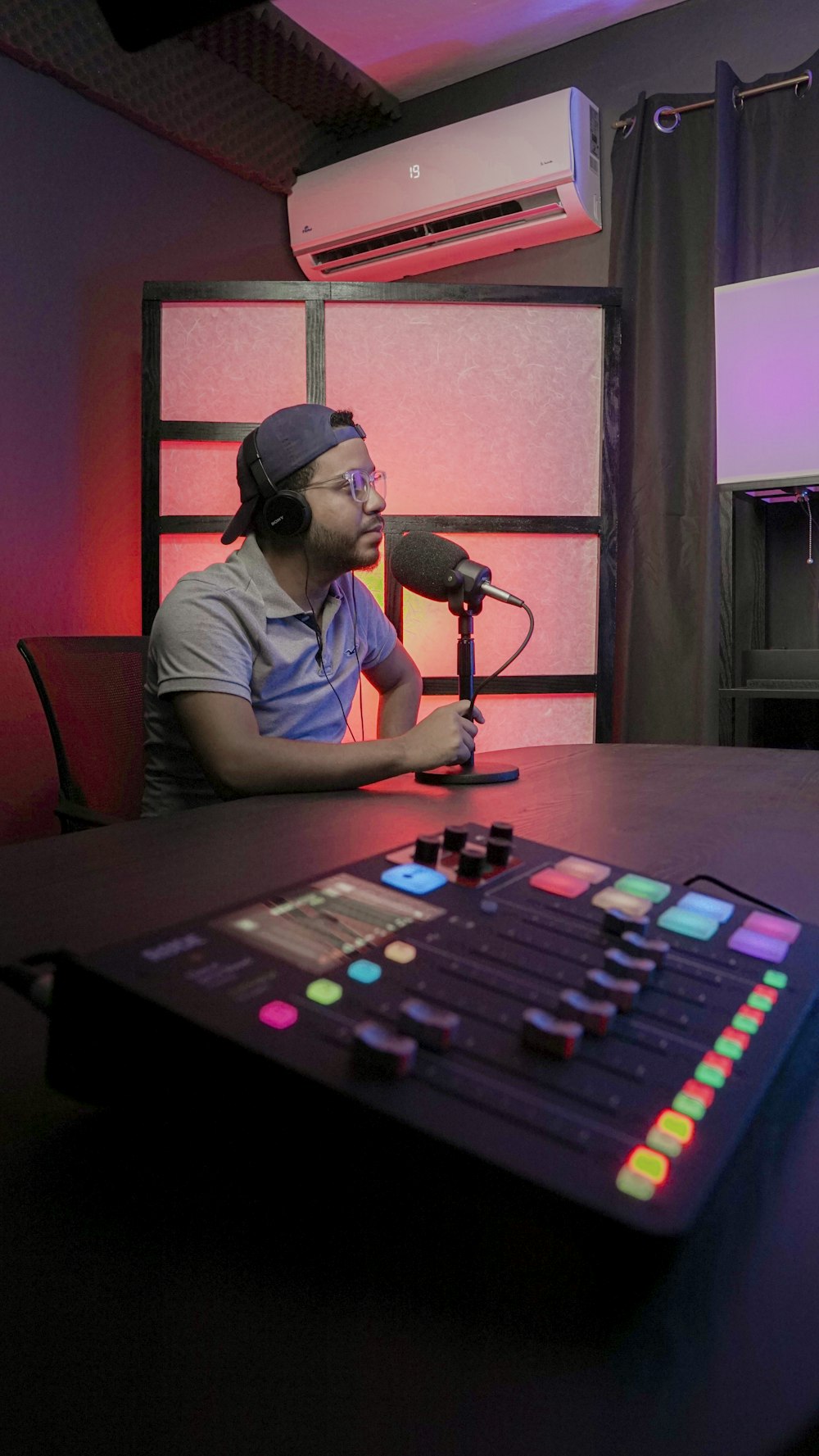 a person wearing headphones and sitting at a table with a microphone