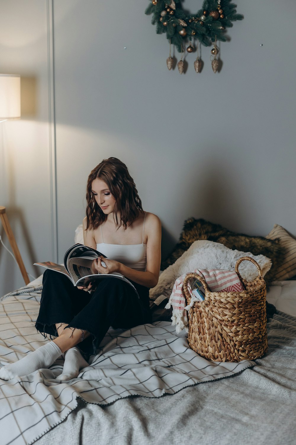 a woman sitting on a bed reading a book