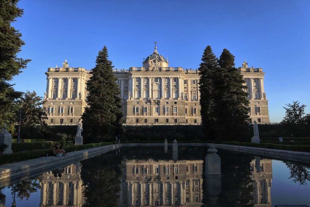 a large building with a pond in front of it