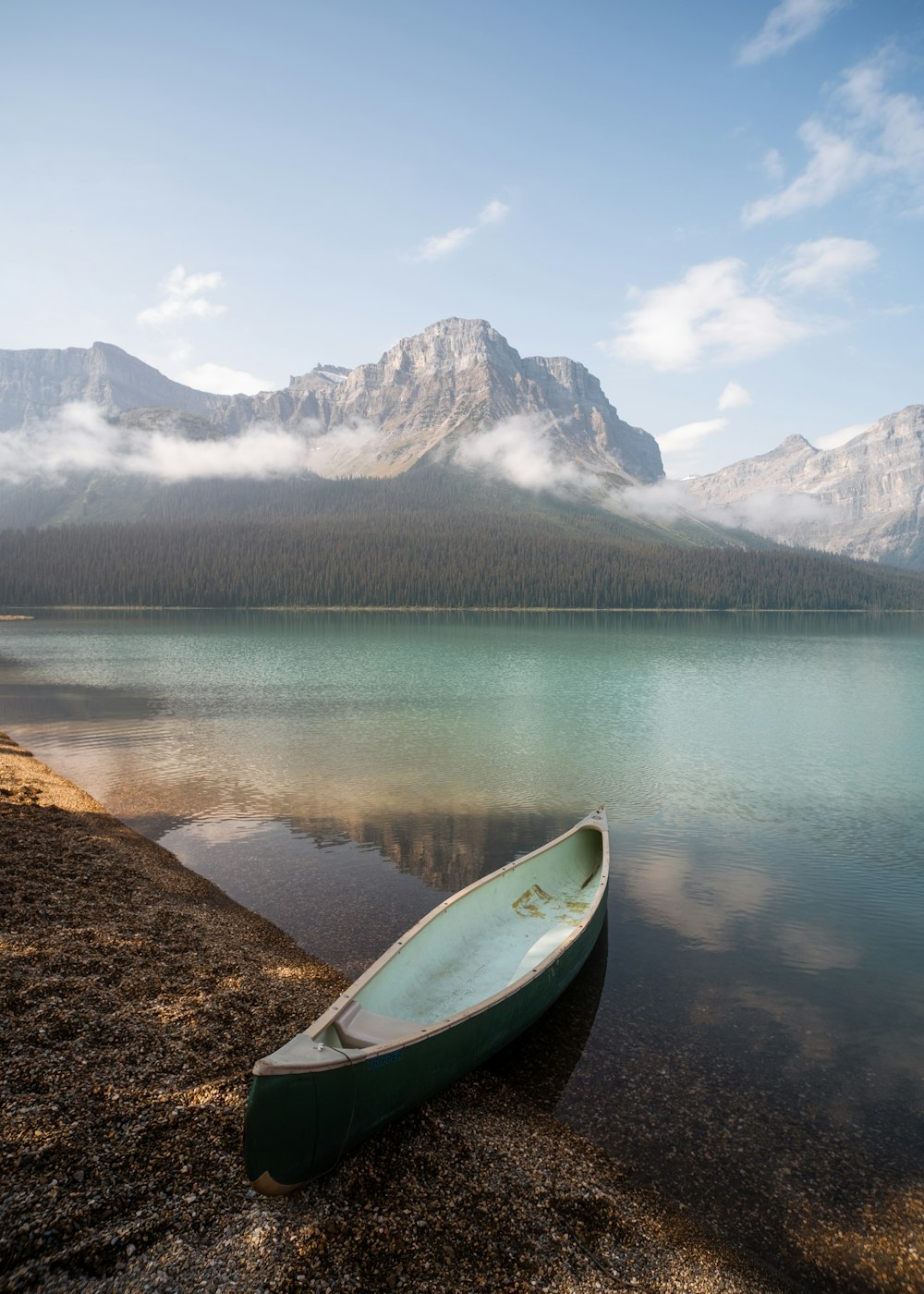 a surfboard on a rock by a lake