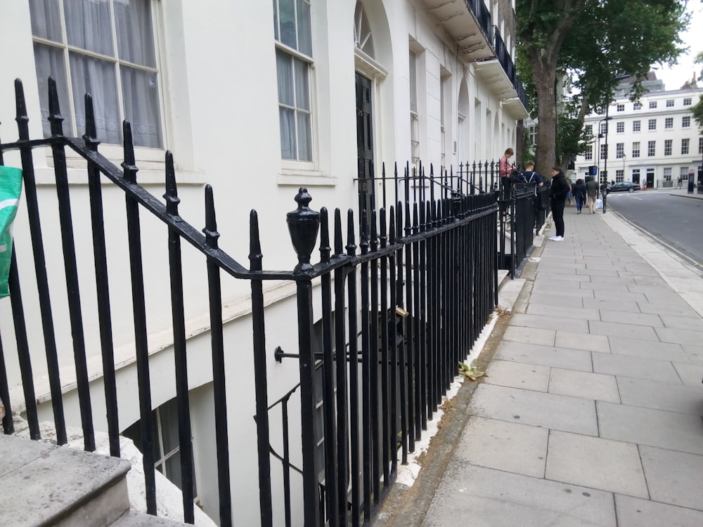 a black fence on a sidewalk