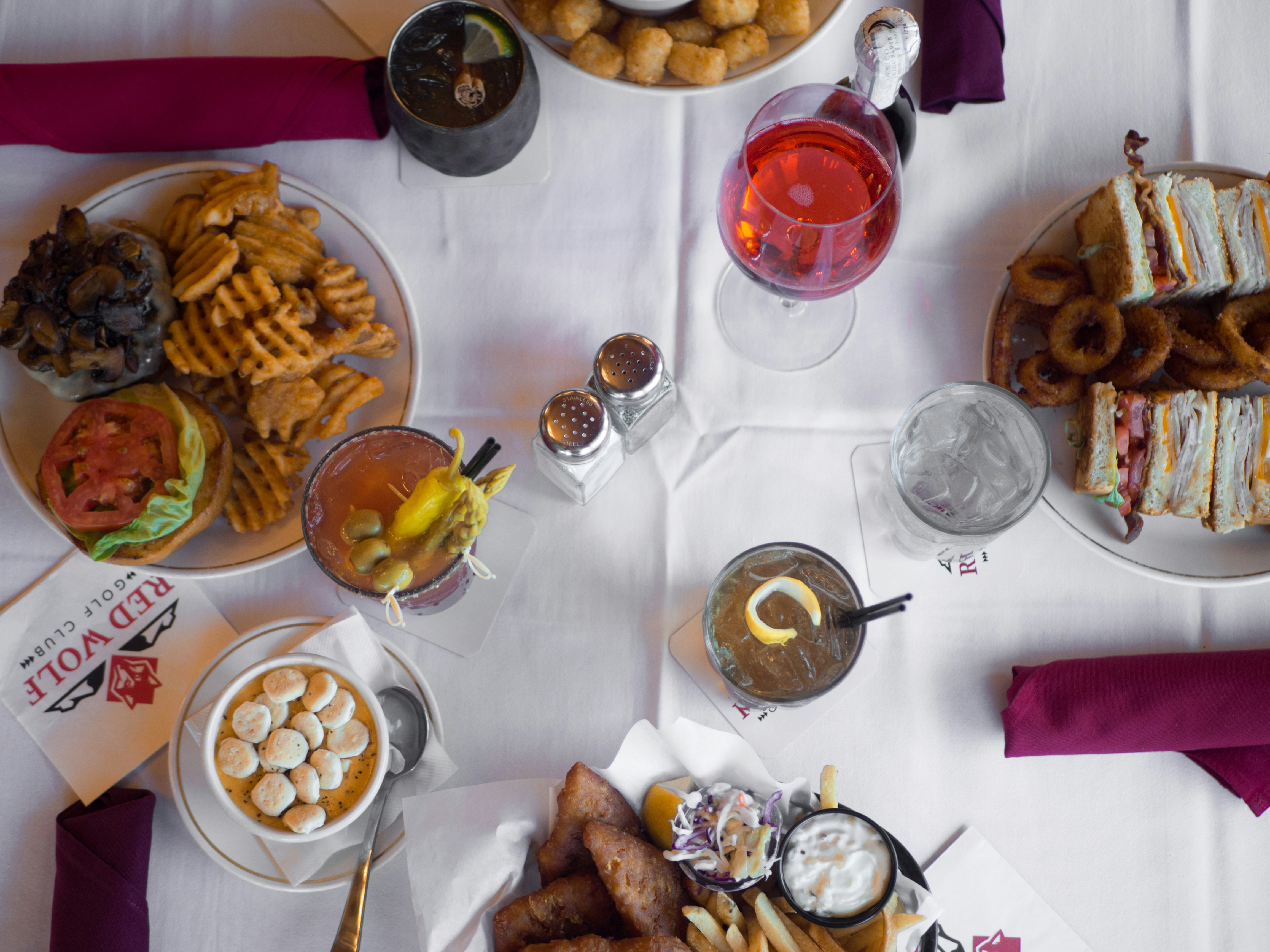 Overhead view of colorful restaurant spread with multiple dishes on bright white table