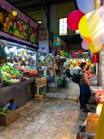 A colorful local market scene with fresh produce and smiling vendors.