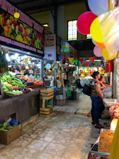 A vibrant food market scene with colorful fresh produce and happy customers.