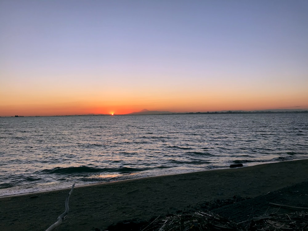 a beach with waves and a sunset