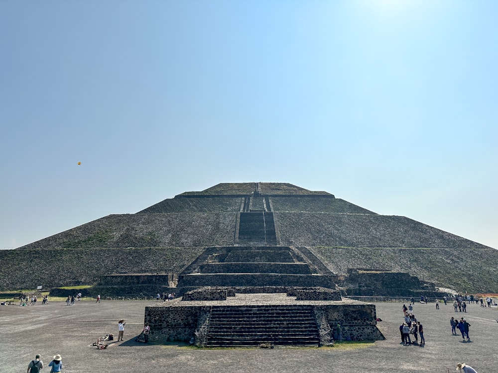 a large pyramid with people around it