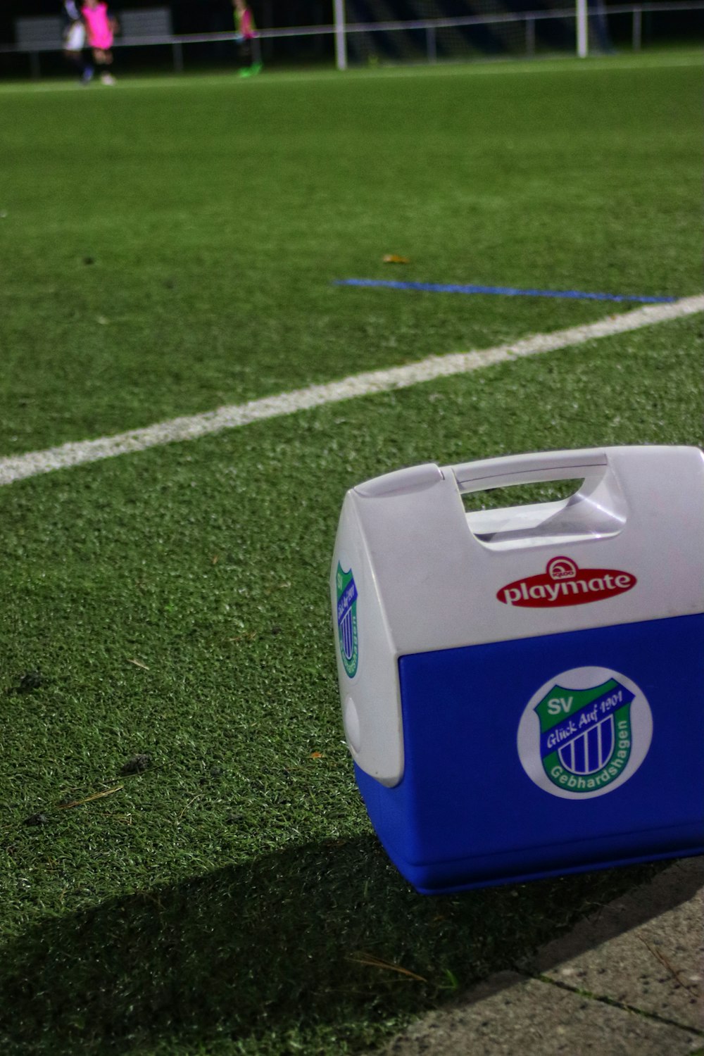 a white and blue box on a grass field