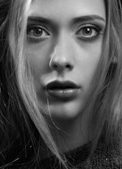 Black and white close-up portrait with intense shadows accentuating every detail.