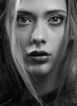 Black and white close-up portrait with intense shadows accentuating every detail.