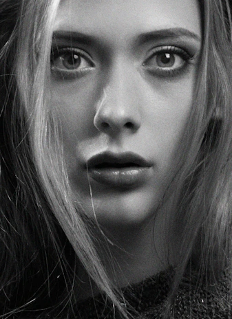 A powerful close-up black-and-white portrait of a focused MMA fighter in the cage under dramatic lighting.