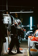 Dynamic shot of pit crew working swiftly under dark mode aesthetics with carbon fiber textures.