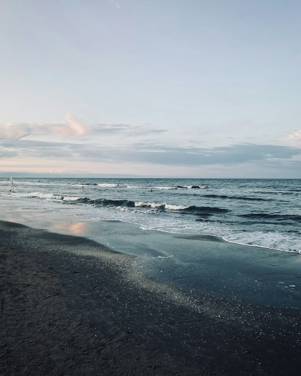 a beach with waves and a blue sky