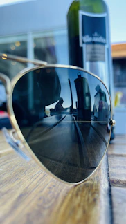 Close-up of sleek, modern sunglasses resting on a wooden table at sunset.