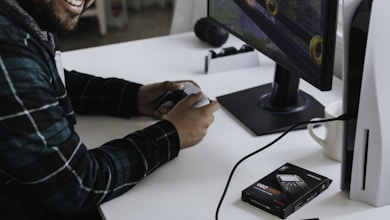 a man wearing headphones and sitting at a desk with a computer