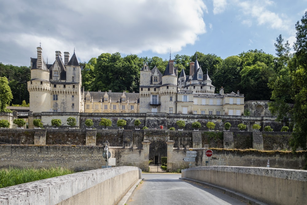 une route avec un mur de pierre et un bâtiment de l’autre côté