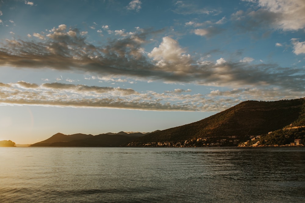 a body of water with hills in the background