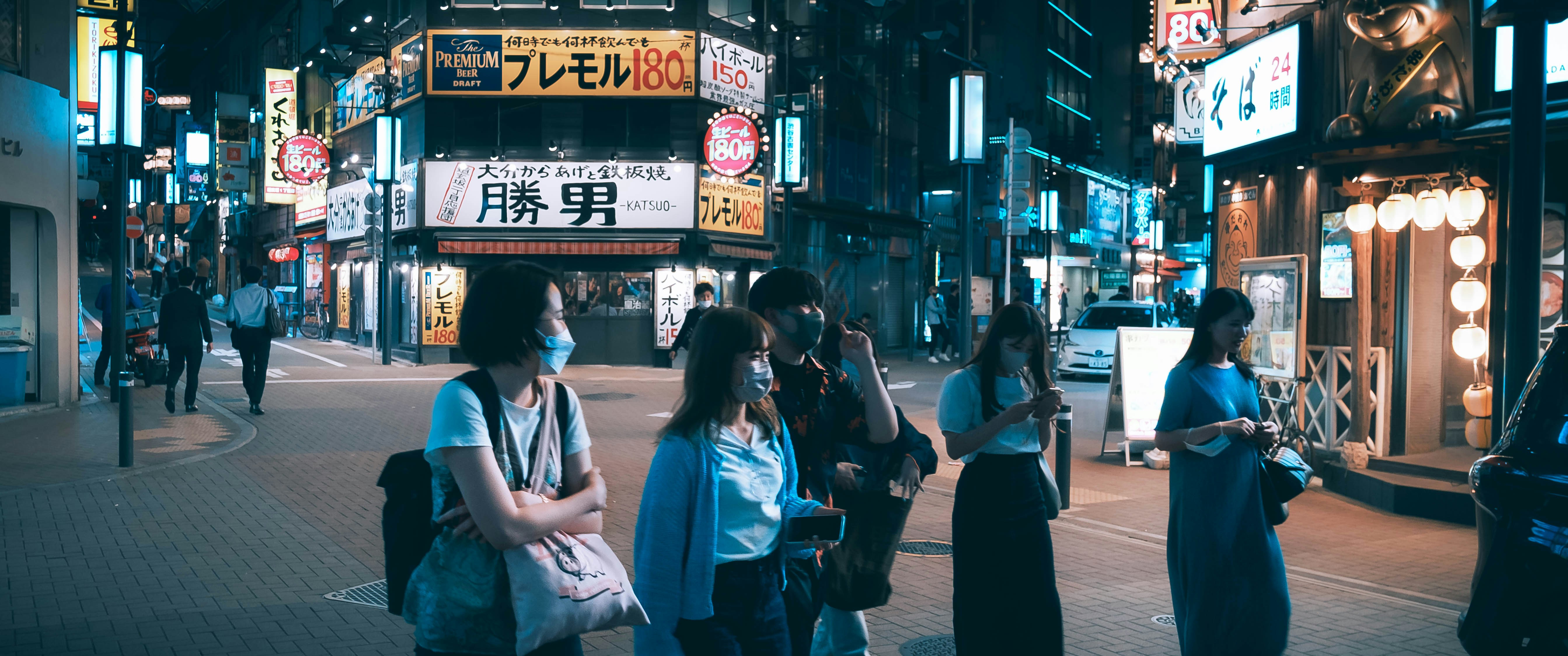 a group of people walking on a sidewalk in a city