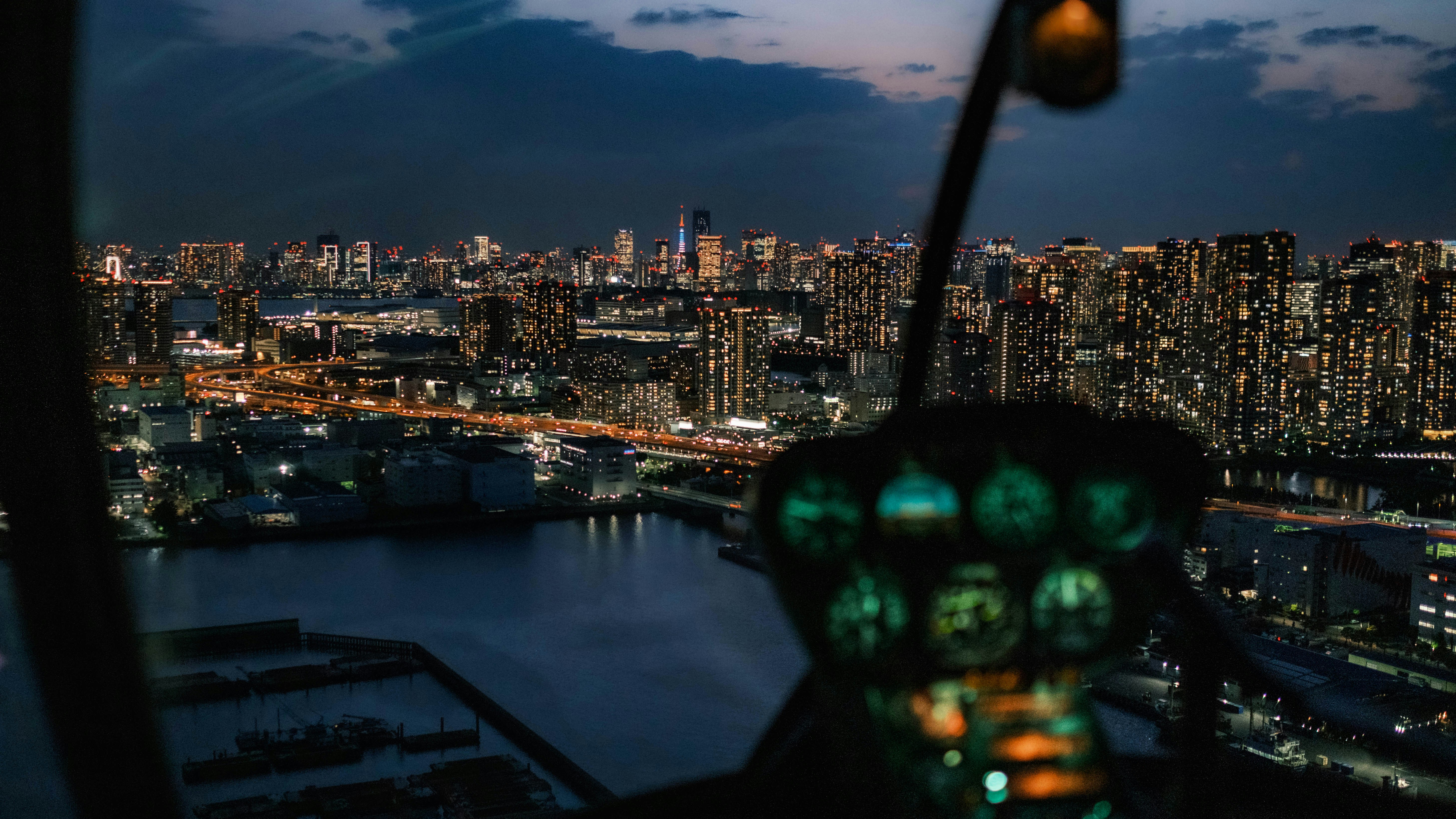 a view of a city at night, Approaching Tokyo in a helicopter with Tokyo Tower in the distance