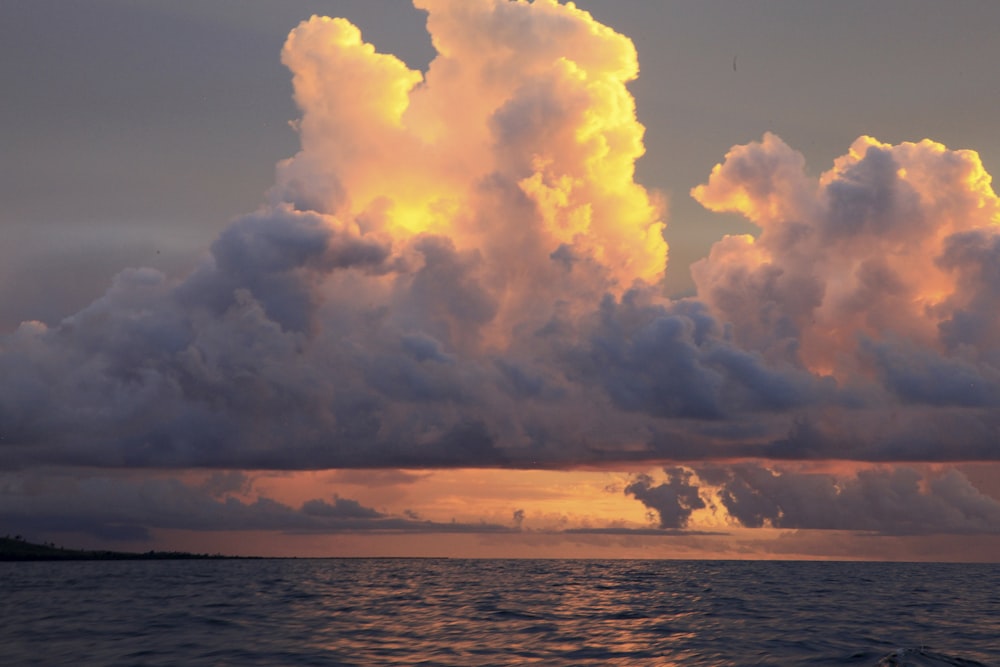 a body of water with clouds above it