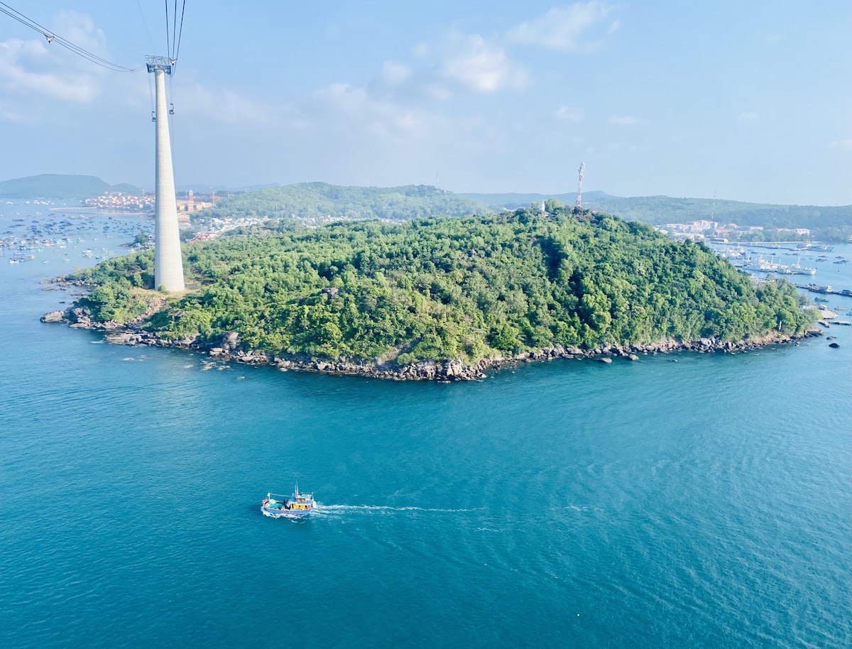 Phu Quoc September — aerial view of the island coastline and cable car tower during the wet season