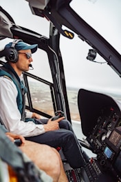 A pilot wearing mixed reality goggles operating a helicopter simulator with six-axis motion platform.