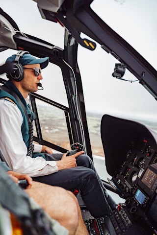 A pilot wearing mixed reality goggles operating a helicopter simulator with six-axis motion platform.