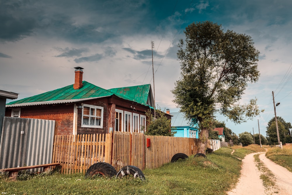 a house with a fence and a tree in the front