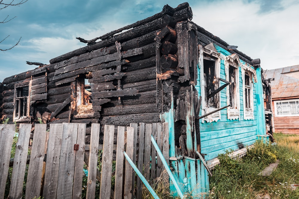 a dilapidated house with a fence