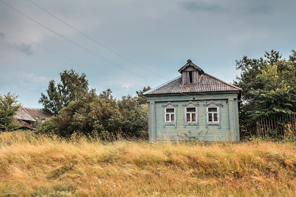 a small blue house in a field