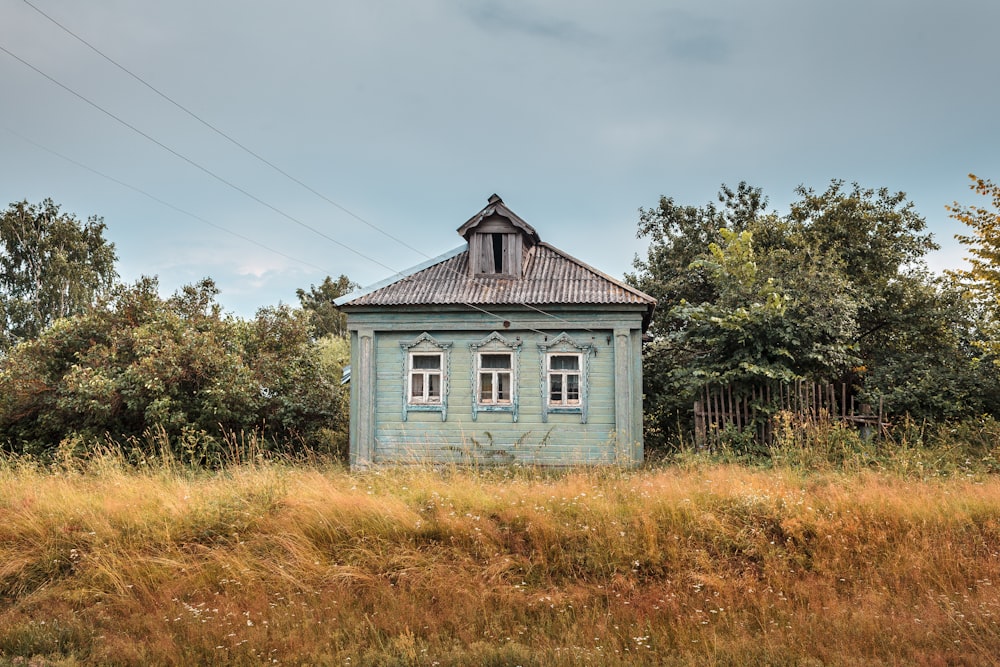 a small blue house in a field