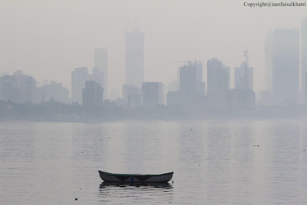 a boat in the water with a city in the background