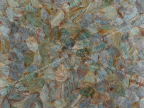 An arrangement of leaf-like gemstones in various shades of green, blue, and brown is spread across the surface, creating an intricate and natural pattern.