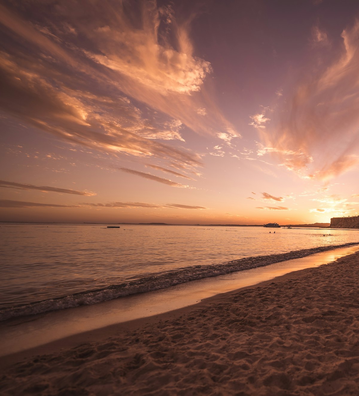 Tramonto dorato sul Mar Rosso con spiaggia sabbiosa e cielo colorato in Egitto