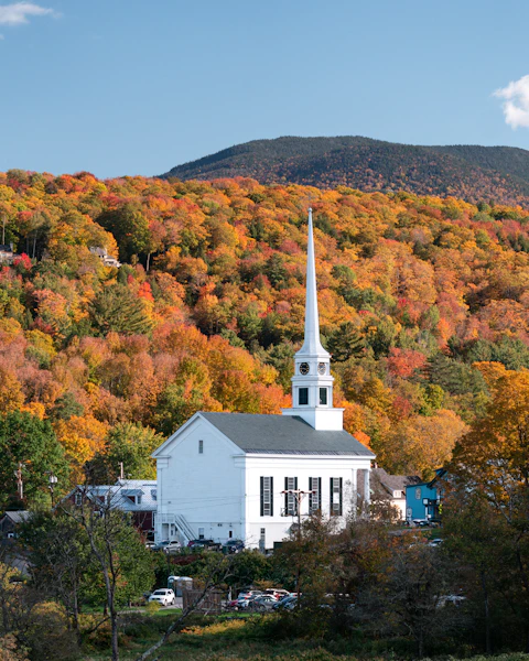 Vermont church steeple surrounded by fall foliage