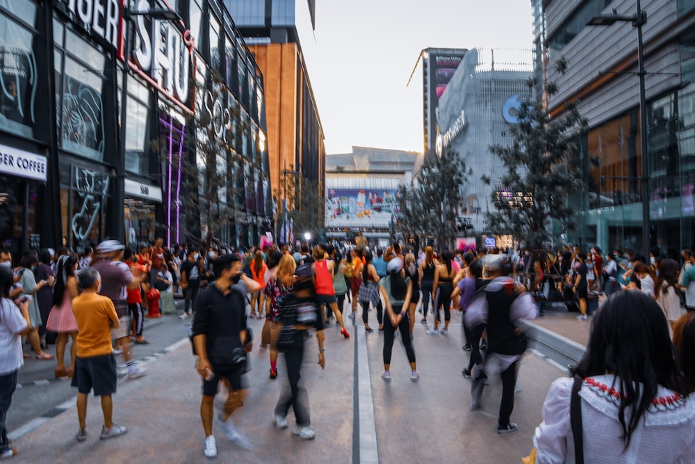 a crowd of people walking on a street between buildings