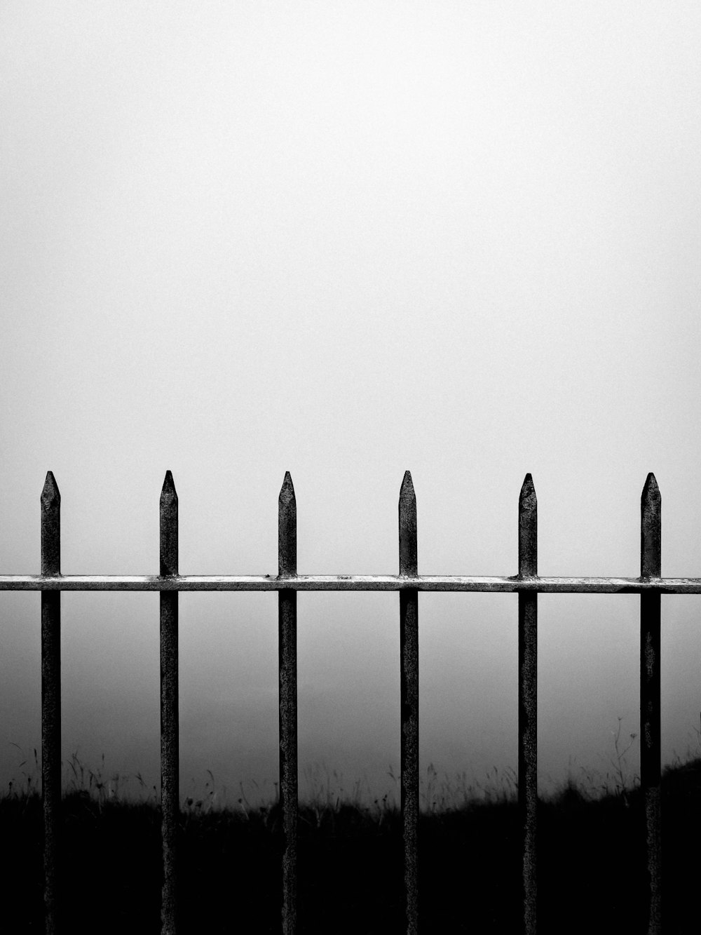 a fence with a field in the background