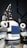 The image features a humanoid robot with mechanical arms and a screen on its chest. The robot has a sleek design with a combination of white, gray, and black colors. It appears to have multiple joints and components, giving it a complex, technical appearance.