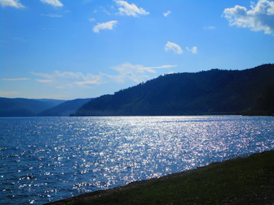 A serene lakeside view near Erba with gentle waves reflecting the sky at dusk.