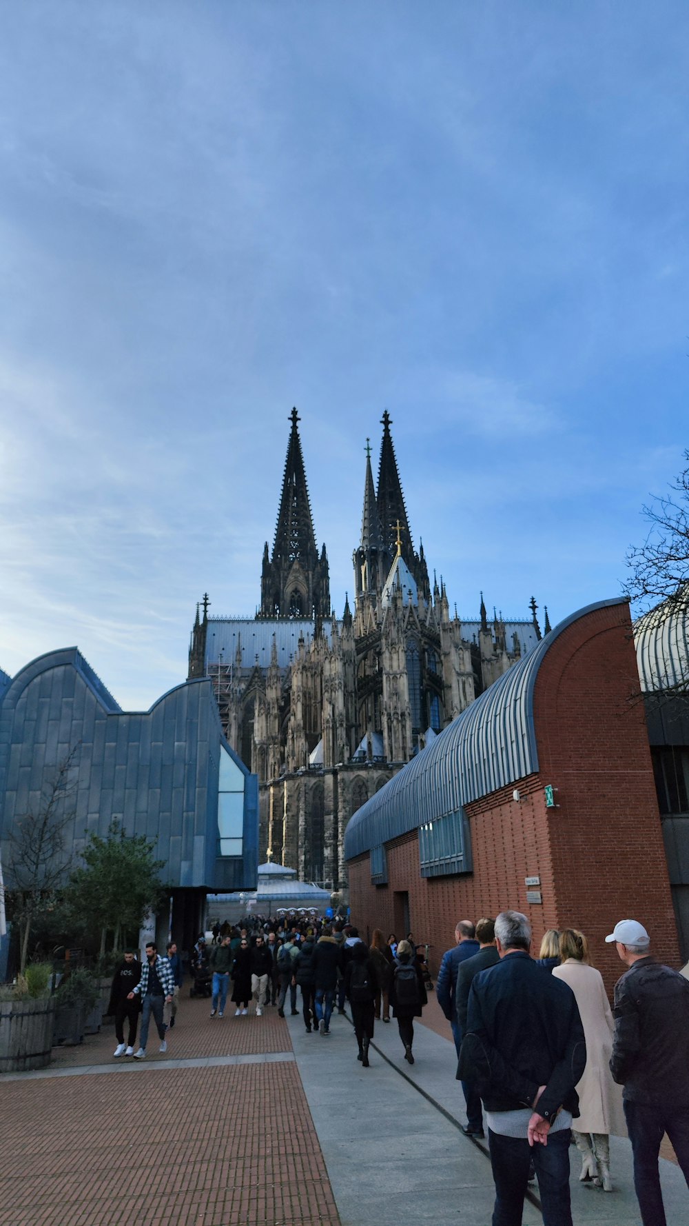 a group of people walking outside of a building with towers