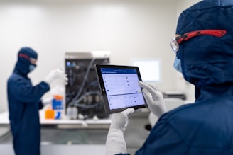 a few people in protective gear using a computer