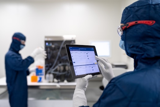 a few people in protective gear using a computer