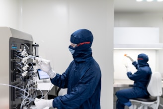 a few people in protective gear working on a computer