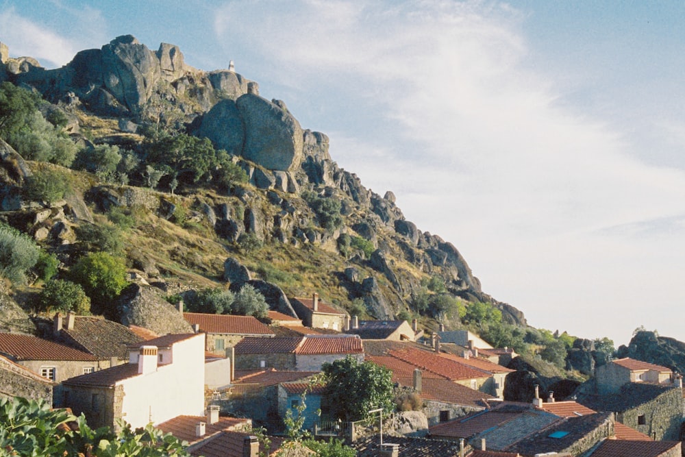 a hillside with buildings and trees with Montserrat in the background