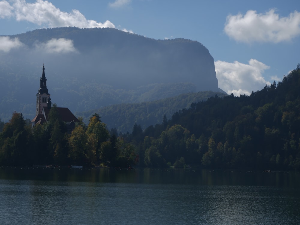 a building on a hill by a lake